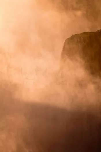 Rots in mist van opstuivend water bij de Victoriawatervallen in Livingstone