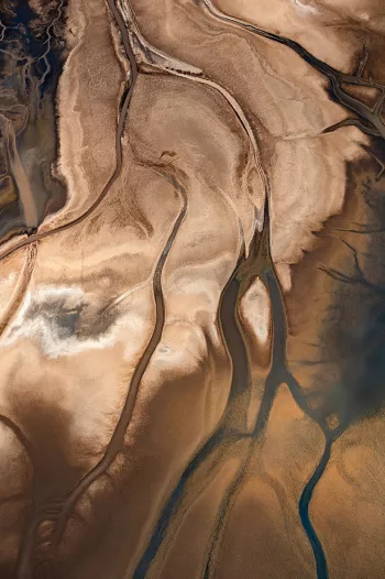 Rivierdelta in bruin en blauw vanuit vogelperspectief